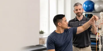 Physiotherapist assessing shoulder pain in a patient at Motion Plus Physiotherapy in Guelph